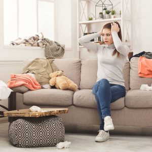 frustrated woman sitting surrounded by too much stuff