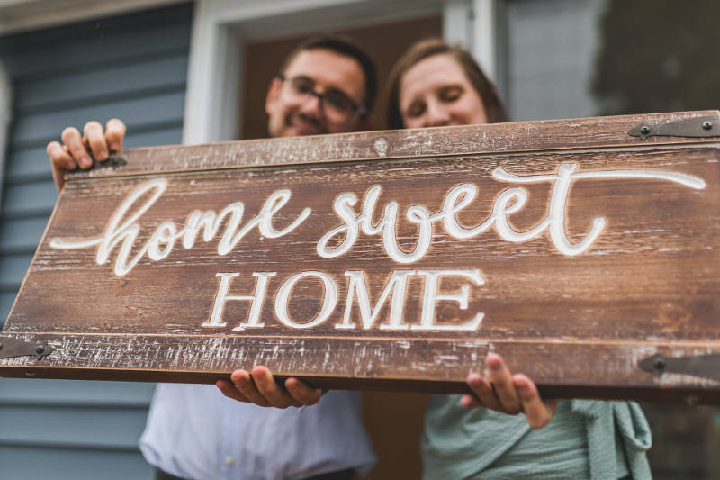 couple h olding home sweet  home sign