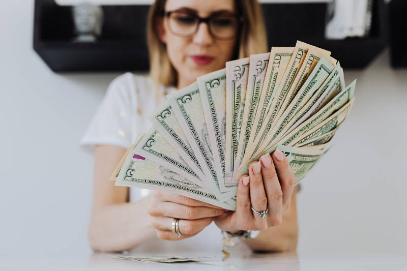 young woman with her hand full of cash