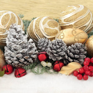 pine cones, christmas ornaments and cranberries on a snowy background