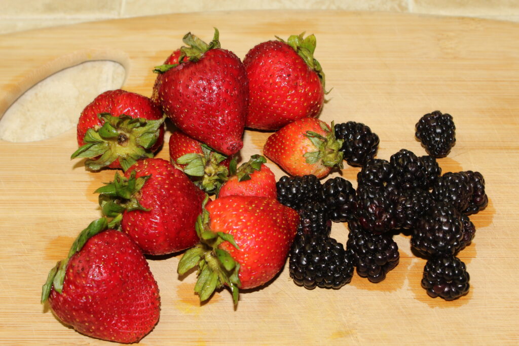 fresh blackberries & strawberries on a cutting board