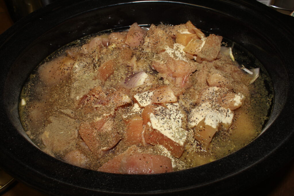 uncooked ingredients for chicken zoodle soup in slow cooker